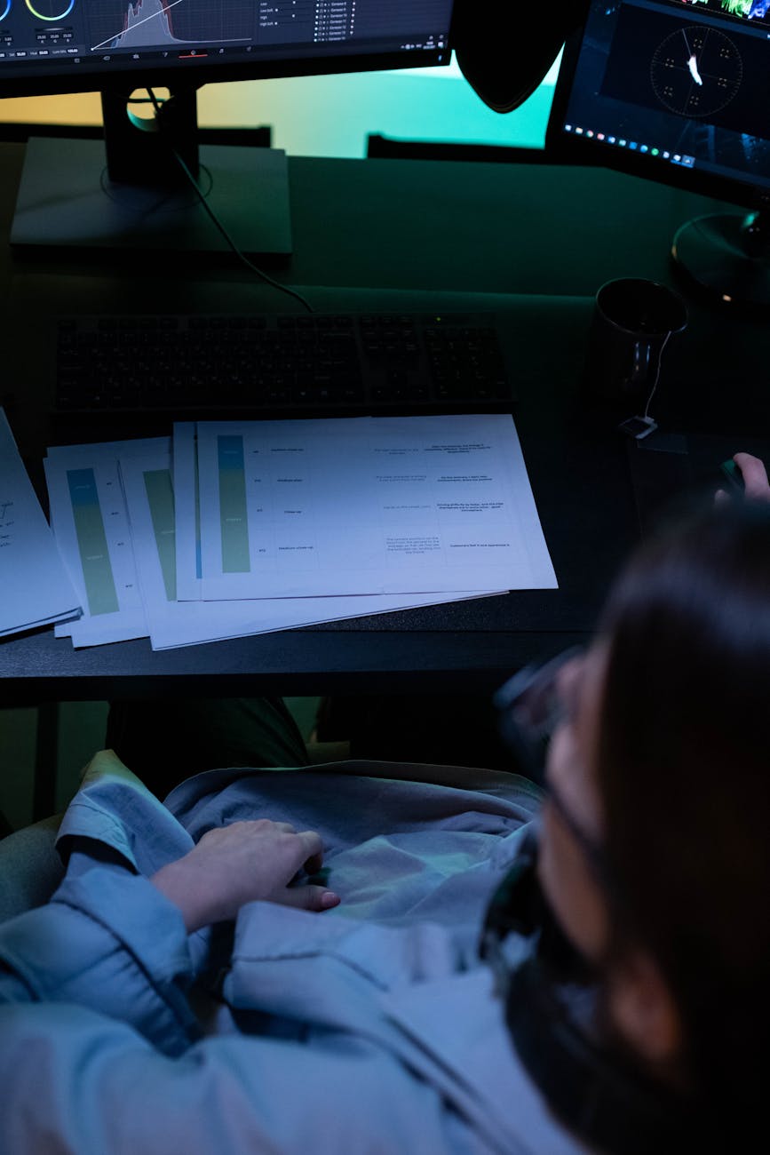 Accountant at dual-monitor workstation reviewing financial reports in modern office