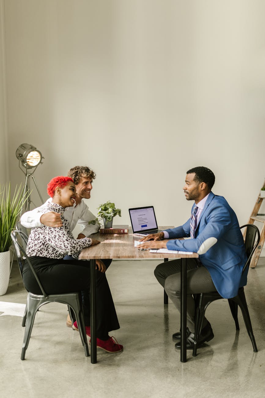 Insurance professional meeting with client couple at office conference table