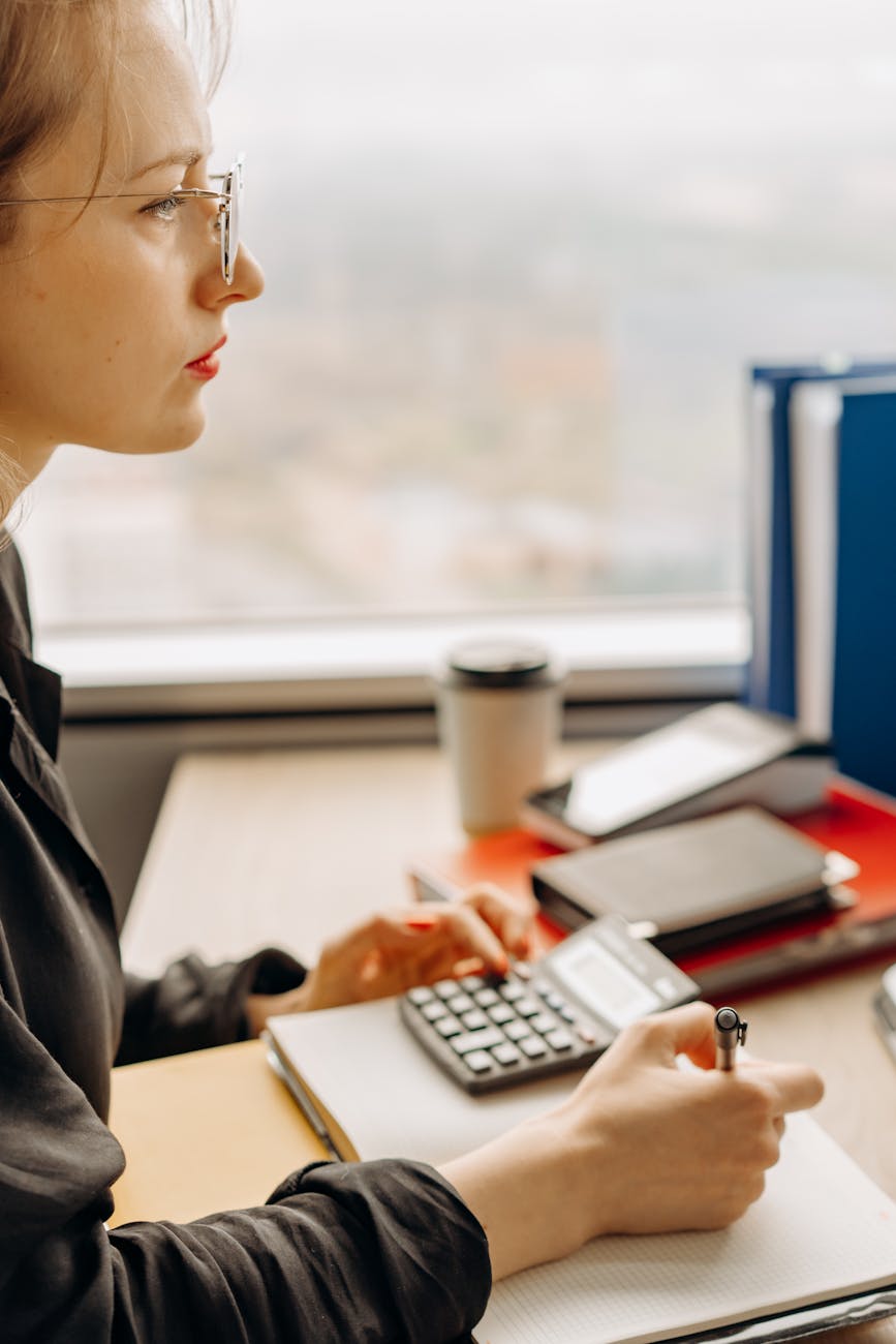 Bookkeeper working on financial spreadsheet at standing desk in bright office